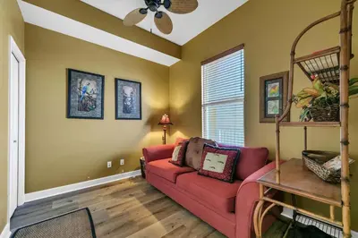 a living room with a red couch and a fan at Grandview East 1604 in Panama City Beach