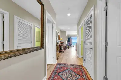 a hallway with a mirror and a rug at Grandview East 1604 in Panama City Beach