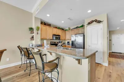 a kitchen with a counter with chairs around it at Grandview East 1604 in Panama City Beach