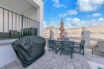 a patio with two chairs and a table and an umbrella at Golden Seashell West in Panama City Beach