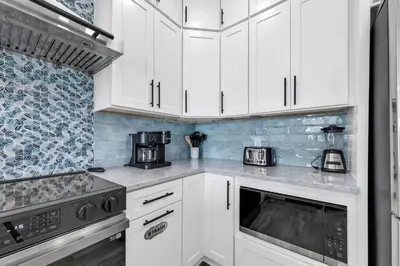 a white kitchen with white cabinets and appliances at Golden Seashell West in Panama City Beach