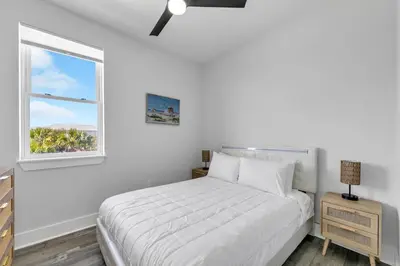 a white bedroom with a bed and a window at Golden Seashell West in Panama City Beach