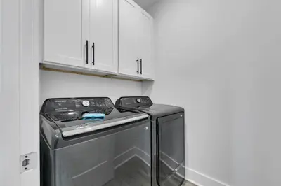 a washer and dryer in a laundry room with white cabinets at Golden Seashell West in Panama City Beach