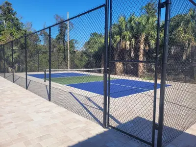 a chain link fence with two tennis courts at Southwinds I-5 in Panama City Beach