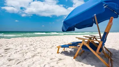 a beach chair and an umbrella on the beach at 429 S Bridge Ln 107A in Watersound Beach