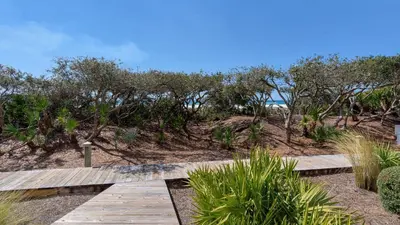 a wooden path on the beach with the ocean in the background at 429 S Bridge Ln 107A in Watersound Beach