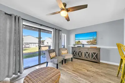 a living room with a ceiling fan and a window at Endless Summer D5 in Panama City Beach