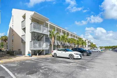 a white car parked in a parking lot in front of a building at Endless Summer D5 in Panama City Beach