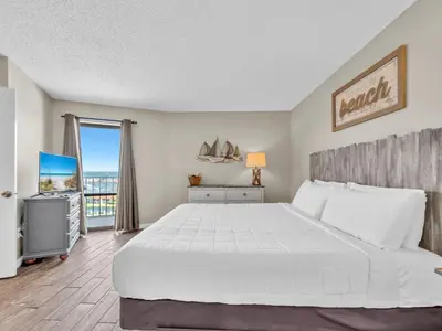 a bedroom with a large bed and a balcony at Edgewater Tower 3-1110 - South of Heaven in Panama City Beach