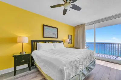 a bedroom with a large bed and a balcony at Majestic Beach Towers 2-1801 in Panama City Beach