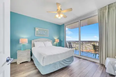 a bedroom with a bed and a balcony at Majestic Beach Towers 2-1801 in Panama City Beach
