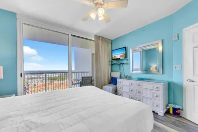a bedroom with a large bed and a balcony at Majestic Beach Towers 2-1801 in Panama City Beach