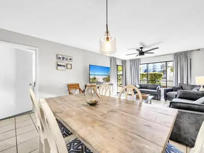 a dining room and living room with a table and chairs at Edgewater Golf Villa 3204 in Panama City Beach