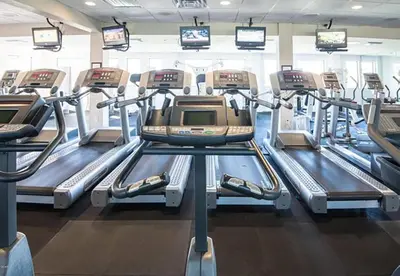 a gym with several tread machines and televisions at Edgewater Golf Villa 3204 in Panama City Beach