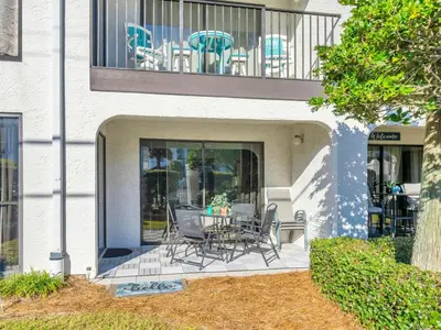 a patio with chairs and a table on a balcony at Edgewater Golf Villa 3204 in Panama City Beach