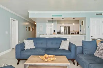 a living room with a blue couch and a table at Fabulous Views at Emerald Beach in Panama City Beach