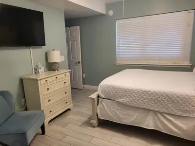 a bedroom with a bed and a tv and a chair at Fabulous Views at Emerald Beach in Panama City Beach
