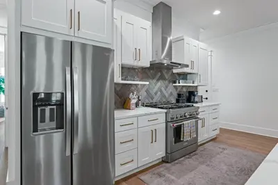 a kitchen with white cabinets and a stainless steel refrigerator at Serenity at Treetop in Inlet Beach