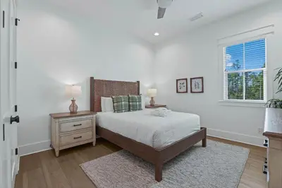 a bedroom with a bed and a nightstand and a window at Serenity at Treetop in Inlet Beach
