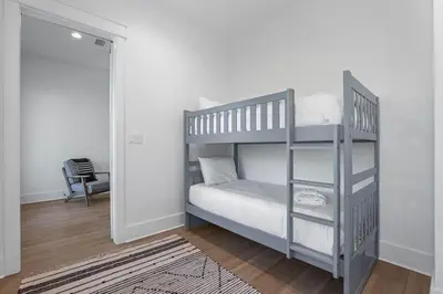 a small bedroom with a bunk bed with a ladder at Serenity at Treetop in Inlet Beach