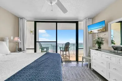 a bedroom with a bed and a view of the ocean at Leeward 403 at Edgewater in Panama City Beach