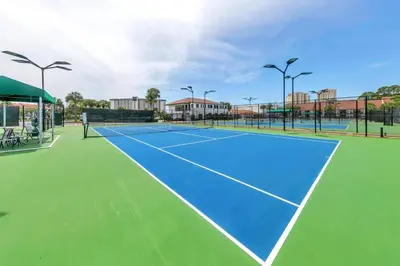 a tennis court with a blue and green at Leeward 403 at Edgewater in Panama City Beach
