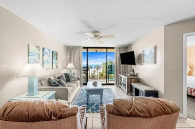 a living room with a couch and a table at East-End PCB Condo with Gulf Views & Beach Access in Panama City Beach