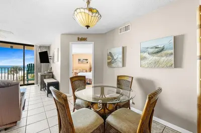 a dining room with a glass table and chairs at East-End PCB Condo with Gulf Views & Beach Access in Panama City Beach