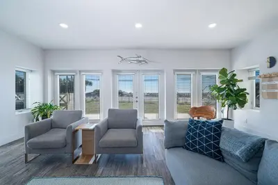 a living room with a couch and two chairs and windows at Private Beach, Heated Pool, Gulf Beach Front in Panama City Beach