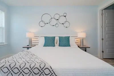 a bedroom with a large white bed with two lamps at Brand New, Steps To Beach, Gulf Views, Heated Pool in Panama City Beach
