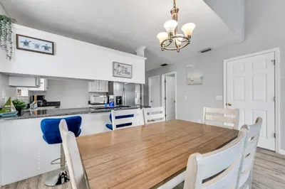 a dining room and kitchen with a table and chairs at High Tides by Emerald Coast Retreats in Panama City Beach