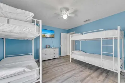 a bedroom with two bunk beds and a ceiling fan at High Tides by Emerald Coast Retreats in Panama City Beach