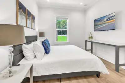 a white bedroom with a bed and a desk at Brand New, Private Pool, Walk To Beach, Game Room in Inlet Beach