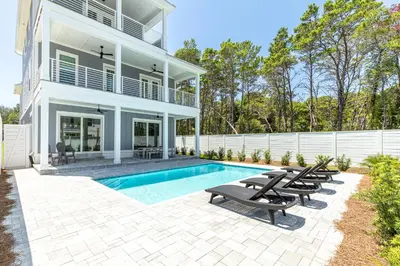 a house with a swimming pool and some chairs at Brand New, Private Pool, Walk To Beach, Game Room in Inlet Beach