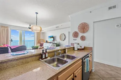 a kitchen with a sink and a view of the ocean at Beachfront Bliss at Ocean Ritz! 3BR 3BA! Sleeps 10 by Dolce Vita Getaways PCB in Panama City Beach