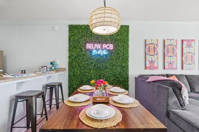 a living room with a table and a green wall at Beachfront Bliss at Ocean Ritz! 3BR 3BA! Sleeps 10 by Dolce Vita Getaways PCB in Panama City Beach