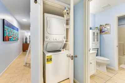 a bathroom with a washing machine and a toilet at Walk to Pool and Beach PCB Resort Getaway with Porch in Panama City Beach