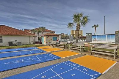 a row of benches sitting next to the beach at Walk to Pool and Beach PCB Resort Getaway with Porch in Panama City Beach