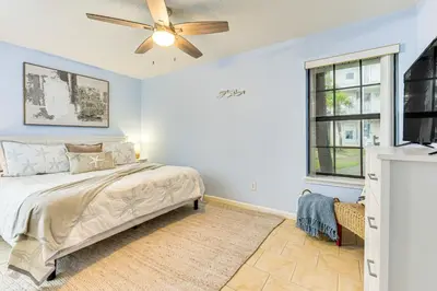 a bedroom with a bed and a ceiling fan at Walk to Pool and Beach PCB Resort Getaway with Porch in Panama City Beach