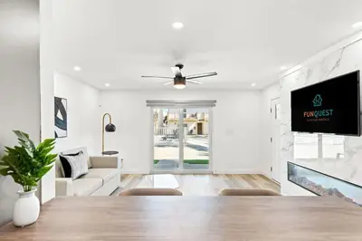 a white living room with a table and a tv at Ocean Breeze 1A in Panama City Beach