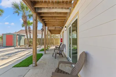 a porch with chairs and a wooden pergola at Ocean Breeze 1B in Panama City Beach