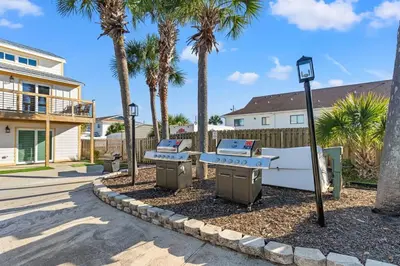a street with two picnic tables and palm trees at Ocean Breeze 1B in Panama City Beach