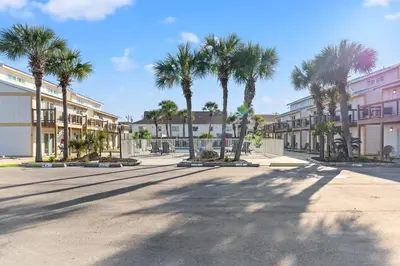 a city street with palm trees and buildings at Ocean Breeze 2A in Panama City Beach