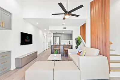 a living room with a white couch and a ceiling fan at Ocean Breeze 1D in Panama City Beach