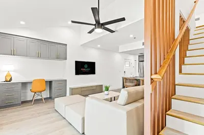 a living room with a white couch and a ceiling fan at Ocean Breeze 1D in Panama City Beach