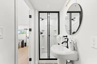a white bathroom with a sink and a mirror at Ocean Breeze 1D in Panama City Beach