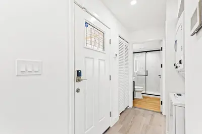 a white bathroom with a toilet and a door at Ocean Breeze 2D in Panama City Beach