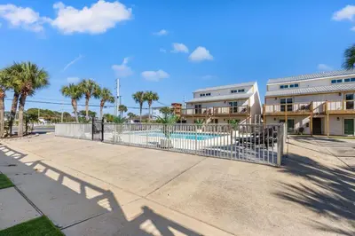a fence in front of a pool with palm trees at Ocean Breeze 3B in Panama City Beach