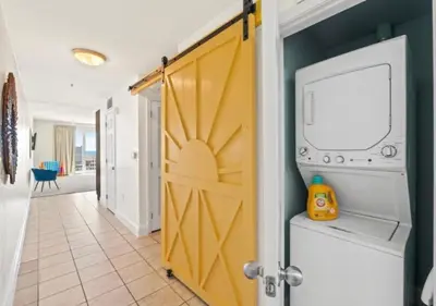 a door to a laundry room with a washer and dryer at BeachFrnt 2 Hottub 5 Pools Jet Ski in Panama City Beach