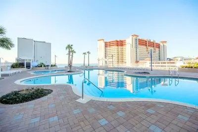 a large swimming pool with buildings in the background at BeachFrnt 2 Hottub 5 Pools Jet Ski in Panama City Beach